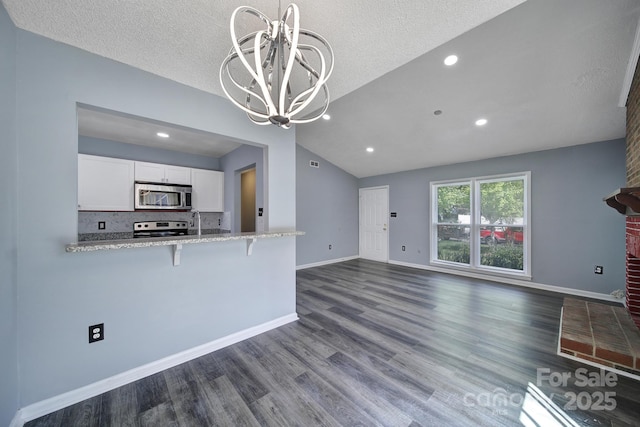 8520 Mission Hills Rd, Charlotte, NC 28227 - unfurnished living room featuring vaulted ceiling, a chandelier, dark wood finished floors, recessed lighting, and a textured ceiling