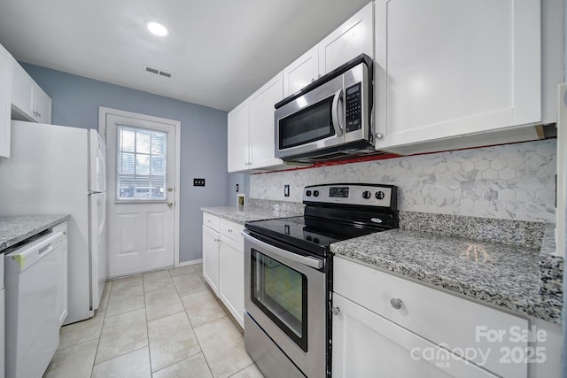 8520 Mission Hills Rd, Charlotte, NC 28227 - kitchen featuring appliances with stainless steel finishes, decorative backsplash, white cabinets, and light stone countertops