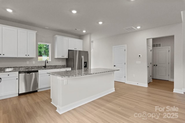 7225 Jerimoth Dr, Charlotte, NC 28215 - kitchen with stainless steel appliances, light wood-style flooring, a kitchen island, a sink, and recessed lighting
