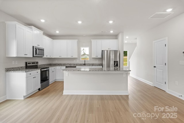 7225 Jerimoth Dr, Charlotte, NC 28215 - kitchen with stainless steel appliances, a sink, light wood-type flooring, a kitchen island, and recessed lighting
