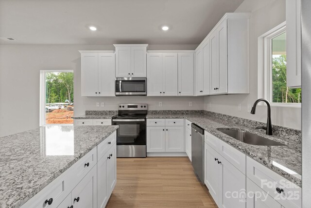 7225 Jerimoth Dr, Charlotte, NC 28215 - kitchen featuring stainless steel appliances, a sink, white cabinets, recessed lighting, and light wood-style floors