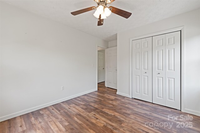 40 Autumn St, Canton, NC 28716 - unfurnished bedroom featuring baseboards, wood finished floors, a closet, and a ceiling fan