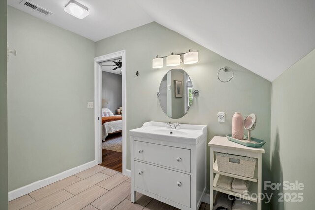 491 Paint Fork Rd, Barnardsville, NC 28709 - ensuite bathroom with vanity, wood tiled floors, vaulted ceiling, and baseboards