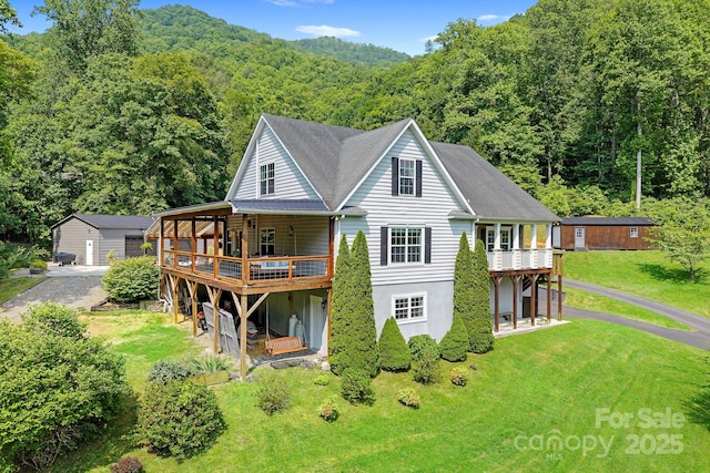491 Paint Fork Rd, Barnardsville, NC 28709 - back of property with a view of trees, gravel driveway, a deck, and a yard