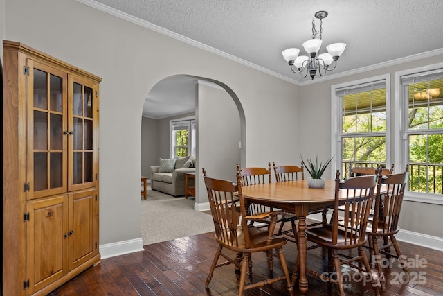 34 Edwards St, Asheville, NC 28806 - dining area featuring arched walkways, healthy amount of natural light, a chandelier, dark wood-style flooring, and a textured ceiling