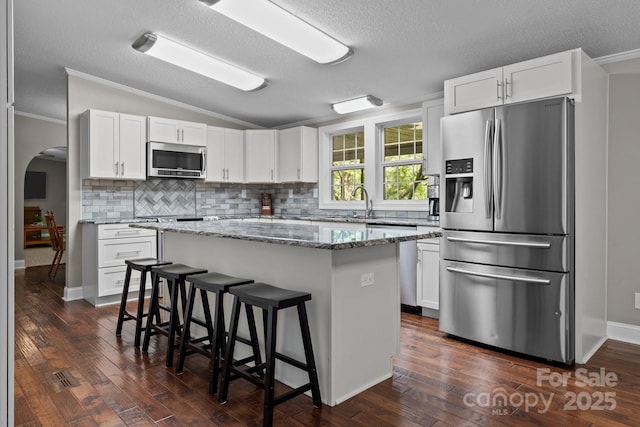 34 Edwards St, Asheville, NC 28806 - kitchen featuring stainless steel appliances, lofted ceiling, a breakfast bar, backsplash, and crown molding