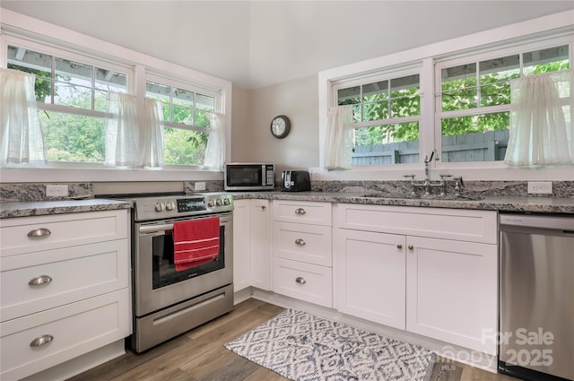 22 Moore Cir, Black Mountain, NC 28711 - kitchen with stainless steel appliances, white cabinets, light stone countertops, and wood finished floors