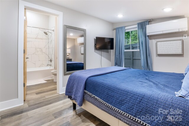 22 Moore Cir, Black Mountain, NC 28711 - bedroom featuring light wood-type flooring, an AC wall unit, recessed lighting, and connected bathroom
