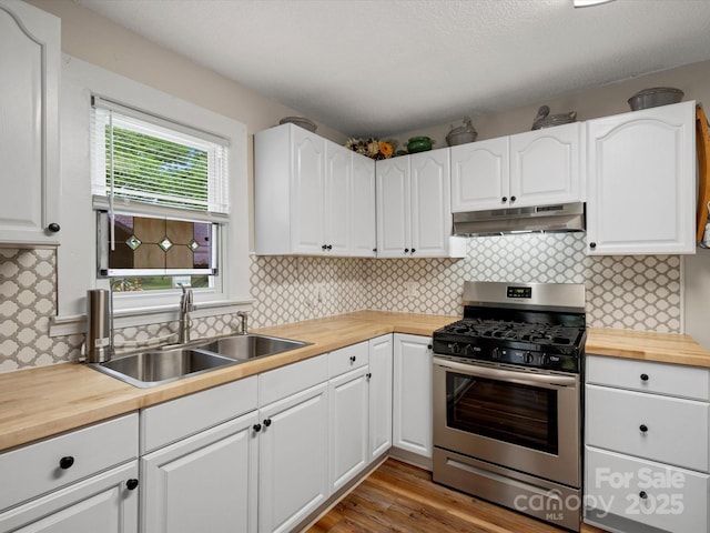 206 Charlotte St, York, SC 29745 - kitchen with stainless steel gas stove, under cabinet range hood, wood counters, a sink, and white cabinetry