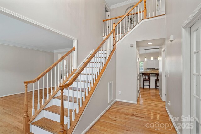 3830 Waters Reach Ln, Indian Trail, NC 28079 - stairs with wood finished floors, a towering ceiling, and crown molding
