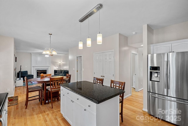 3830 Waters Reach Ln, Indian Trail, NC 28079 - kitchen featuring stainless steel fridge, a fireplace, a kitchen bar, and light wood-type flooring