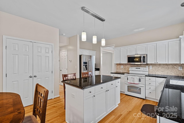 3830 Waters Reach Ln, Indian Trail, NC 28079 - kitchen featuring appliances with stainless steel finishes, white cabinetry, light wood-style floors, and a kitchen island