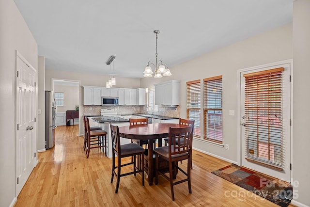 3830 Waters Reach Ln, Indian Trail, NC 28079 - dining area featuring light wood finished floors, a chandelier, and plenty of natural light