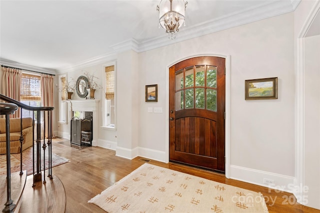 1728 Shadow Forest Dr, Matthews, NC 28105 - entrance foyer with arched walkways, baseboards, wood finished floors, ornamental molding, and a high end fireplace