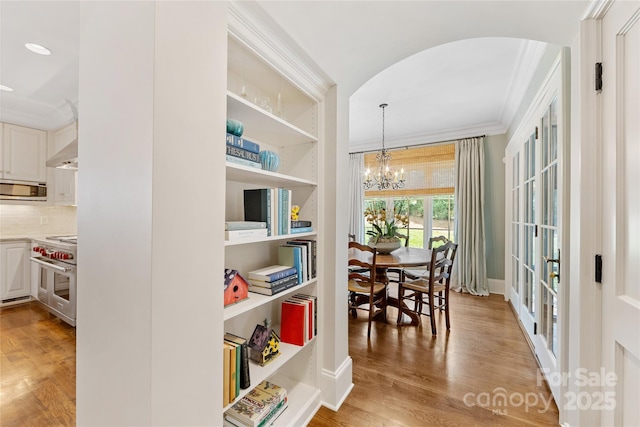 1728 Shadow Forest Dr, Matthews, NC 28105 - dining space with ornamental molding, arched walkways, light wood-style floors, a chandelier, and baseboards
