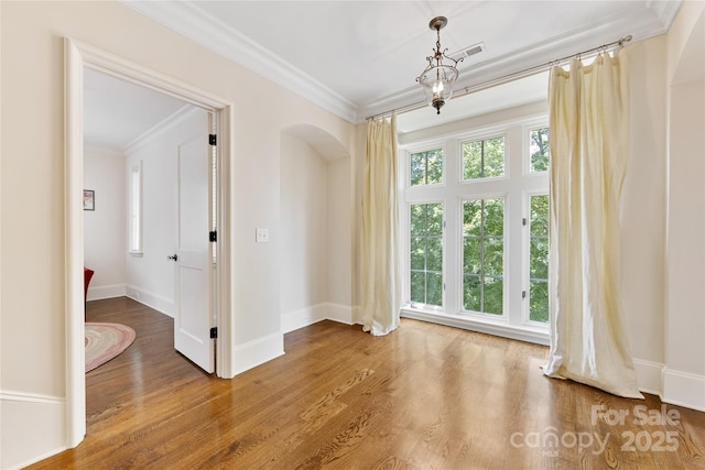 1728 Shadow Forest Dr, Matthews, NC 28105 - spare room featuring ornamental molding, wood finished floors, arched walkways, and baseboards