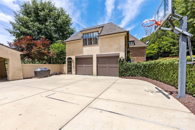 1728 Shadow Forest Dr, Matthews, NC 28105 - view of side of home with stucco siding, a garage, and concrete driveway