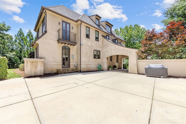 1728 Shadow Forest Dr, Matthews, NC 28105 - back of house with a balcony, stucco siding, concrete driveway, and a patio
