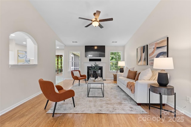 3008 Cornflower Ln, Indian Trail, NC 28079 - living area featuring wood finished floors, a ceiling fan, healthy amount of natural light, lofted ceiling, and a glass covered fireplace