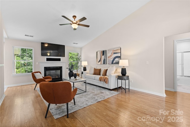 3008 Cornflower Ln, Indian Trail, NC 28079 - living room with a glass covered fireplace, light wood-type flooring, ceiling fan, and high vaulted ceiling
