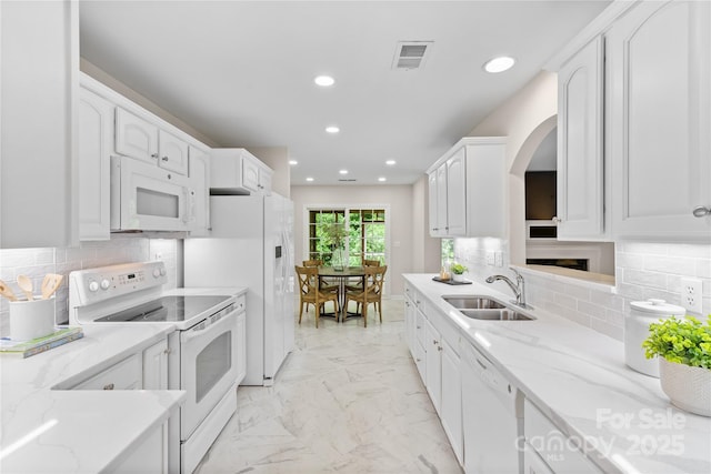3008 Cornflower Ln, Indian Trail, NC 28079 - kitchen featuring white appliances, recessed lighting, white cabinets, arched walkways, and light stone counters