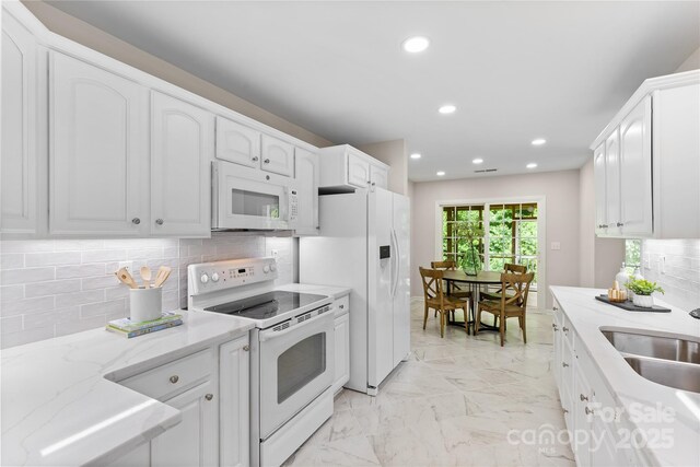 3008 Cornflower Ln, Indian Trail, NC 28079 - kitchen featuring white appliances, light marble finish floors, white cabinets, backsplash, and recessed lighting
