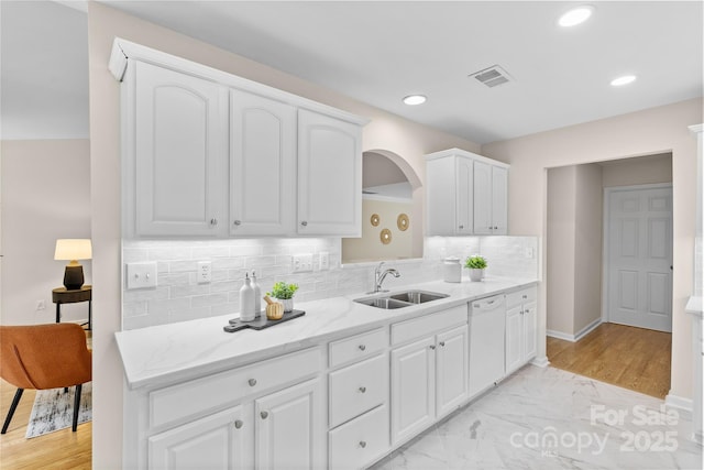 3008 Cornflower Ln, Indian Trail, NC 28079 - kitchen featuring white dishwasher, white cabinets, arched walkways, recessed lighting, and tasteful backsplash