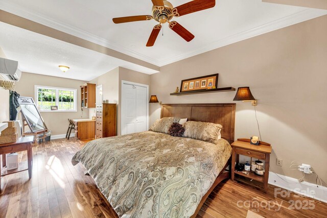 540 Upper Paw Paw Rd, Marshall, NC 28753 - bedroom featuring wood-type flooring, baseboards, a wall mounted AC, crown molding, and ceiling fan