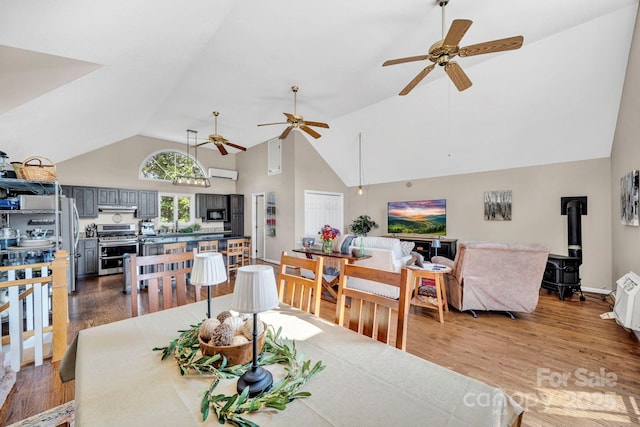 540 Upper Paw Paw Rd, Marshall, NC 28753 - dining area with a wood stove, high vaulted ceiling, ceiling fan, and wood finished floors