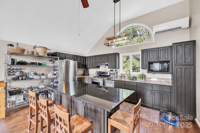 540 Upper Paw Paw Rd, Marshall, NC 28753 - kitchen featuring appliances with stainless steel finishes, a wall mounted air conditioner, under cabinet range hood, high vaulted ceiling, and light wood-style flooring
