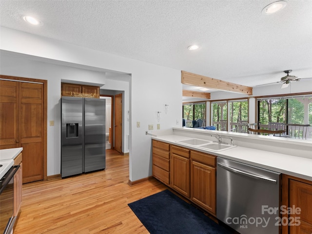 43 Hungryneck Hollow Ln, Saluda, NC 28773 - kitchen featuring stainless steel appliances, a sink, a textured ceiling, light wood finished floors, and light countertops