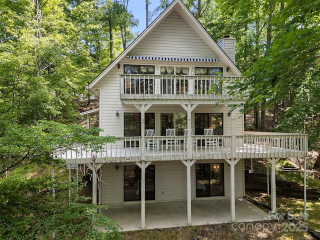 43 Hungryneck Hollow Ln, Saluda, NC 28773 - rear view of property featuring a balcony, a patio, and a chimney