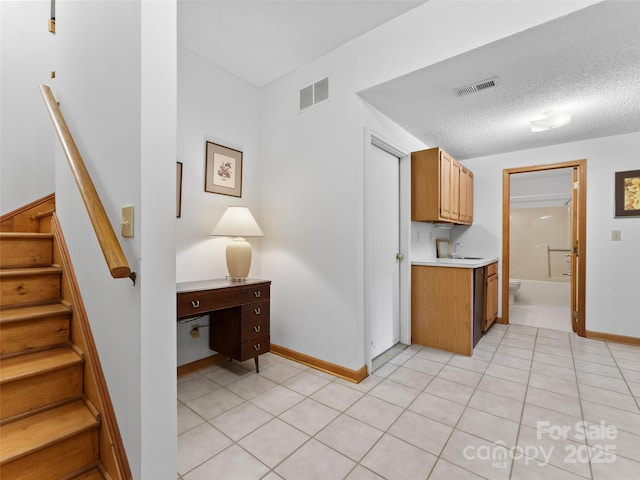 43 Hungryneck Hollow Ln, Saluda, NC 28773 - kitchen featuring light countertops, a sink, brown cabinetry, baseboards, and light tile patterned floors