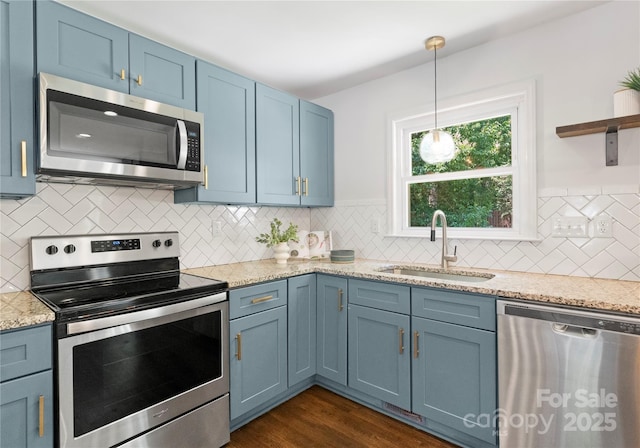 1027 Dresden Dr W, Charlotte, NC 28205 - kitchen with stainless steel appliances, blue cabinetry, backsplash, and light stone counters