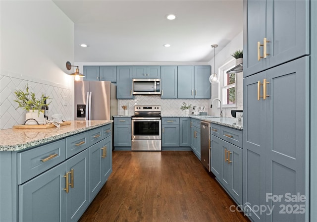 1027 Dresden Dr W, Charlotte, NC 28205 - kitchen with appliances with stainless steel finishes, backsplash, dark wood-style flooring, light stone counters, and recessed lighting