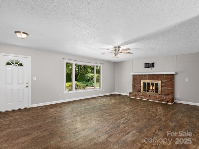 164 Beechwood Dr W, Columbus, NC 28722 - unfurnished living room with a ceiling fan, dark wood-style flooring, a textured ceiling, a fireplace, and baseboards