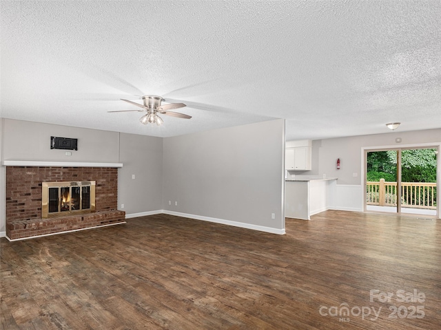164 Beechwood Dr W, Columbus, NC 28722 - unfurnished living room with ceiling fan, a textured ceiling, dark wood-style flooring, a fireplace, and baseboards