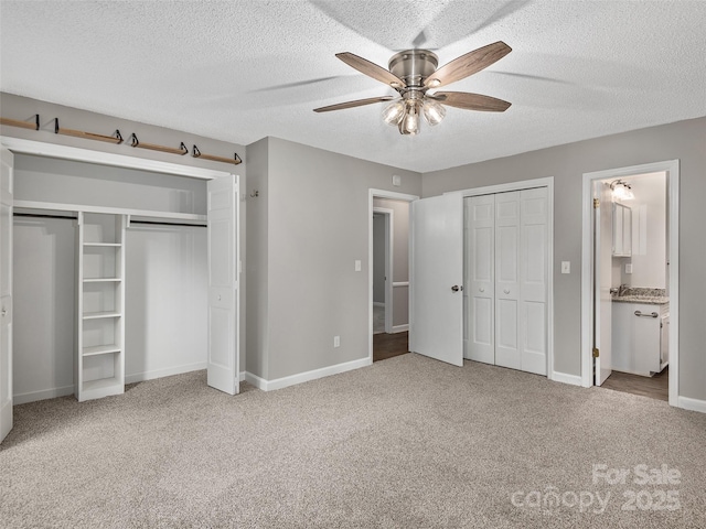 164 Beechwood Dr W, Columbus, NC 28722 - unfurnished bedroom featuring carpet, two closets, a textured ceiling, baseboards, and connected bathroom