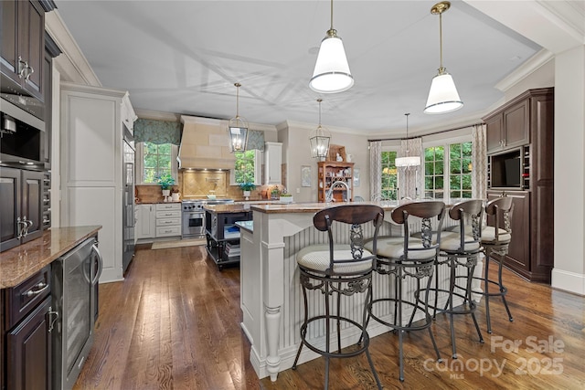 617 Beauhaven Ln, Waxhaw, NC 28173 - kitchen featuring high quality appliances, a kitchen island with sink, wine cooler, custom range hood, and tasteful backsplash