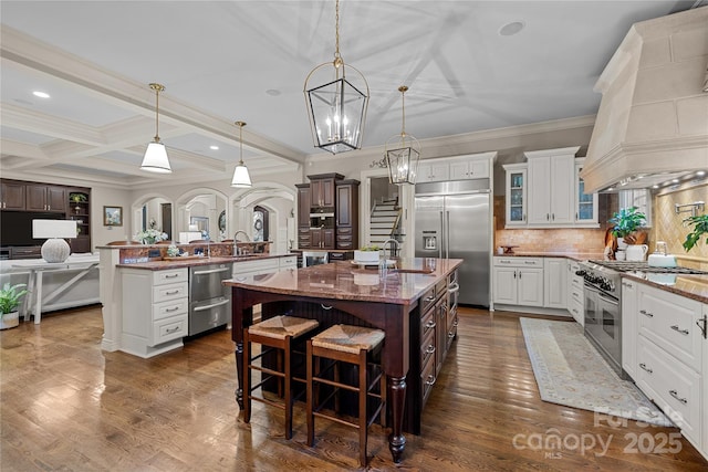 617 Beauhaven Ln, Waxhaw, NC 28173 - kitchen with high quality appliances, premium range hood, an island with sink, tasteful backsplash, and a kitchen bar