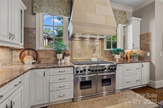 617 Beauhaven Ln, Waxhaw, NC 28173 - kitchen featuring range with two ovens, premium range hood, white cabinets, decorative backsplash, and dark stone counters