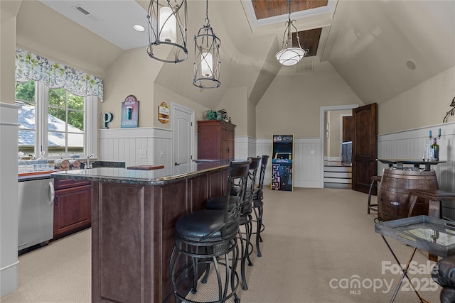 617 Beauhaven Ln, Waxhaw, NC 28173 - kitchen featuring vaulted ceiling, dark countertops, wainscoting, reddish brown cabinets, and a kitchen bar
