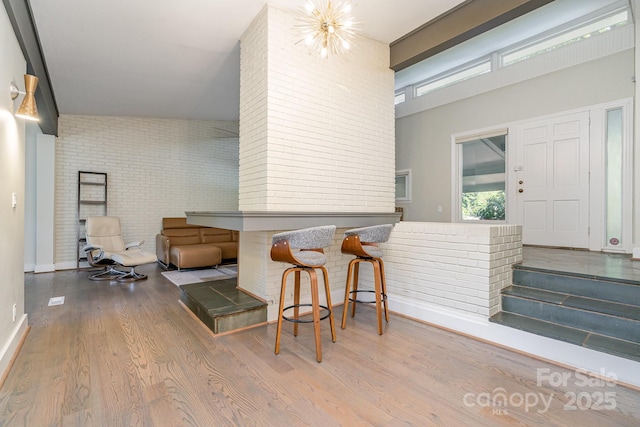 5742 Murrayhill Rd, Charlotte, NC 28210 - interior space with wood finished floors, brick wall, and a chandelier
