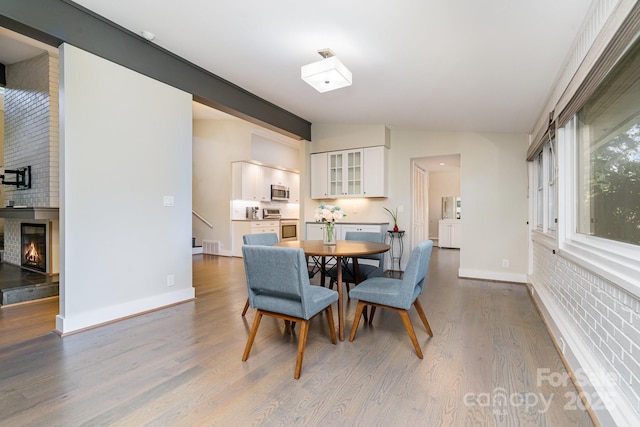 5742 Murrayhill Rd, Charlotte, NC 28210 - dining room with wood finished floors and a brick fireplace