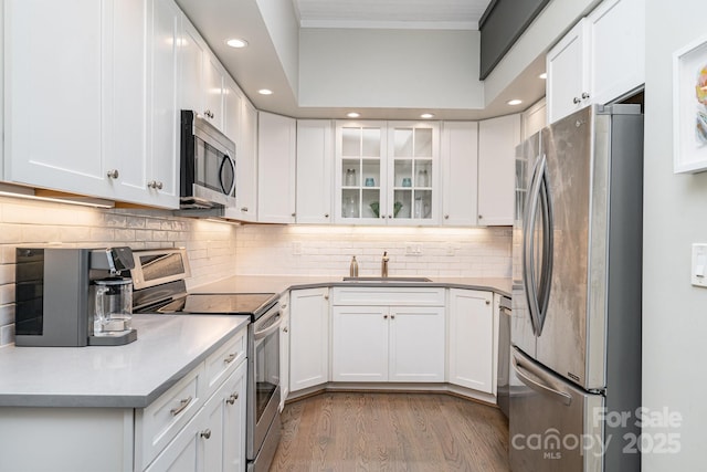 5742 Murrayhill Rd, Charlotte, NC 28210 - kitchen with appliances with stainless steel finishes, recessed lighting, light wood-type flooring, backsplash, and white cabinetry