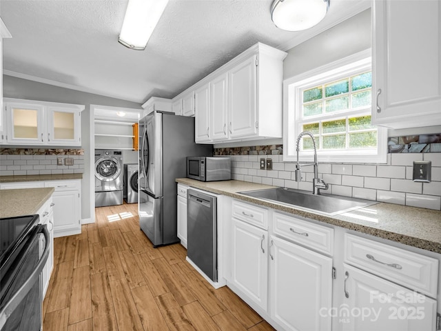 2941 Nix Creek Rd, Marion, NC 28752 - kitchen featuring appliances with stainless steel finishes, a sink, white cabinetry, washer and clothes dryer, and backsplash