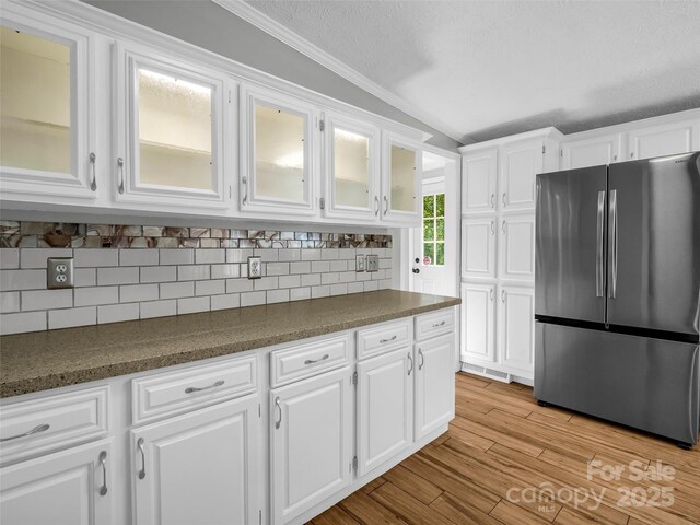 2941 Nix Creek Rd, Marion, NC 28752 - kitchen with freestanding refrigerator, white cabinets, glass insert cabinets, tasteful backsplash, and dark countertops