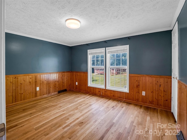 2941 Nix Creek Rd, Marion, NC 28752 - unfurnished room featuring wood finished floors, wainscoting, a textured ceiling, wooden walls, and ornamental molding