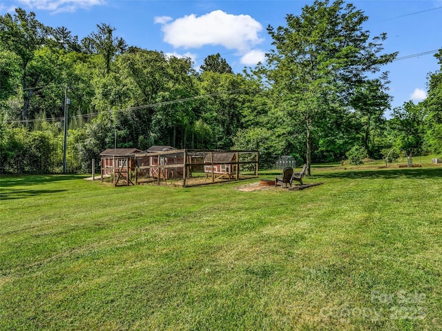 2941 Nix Creek Rd, Marion, NC 28752 - view of green lawn featuring exterior structure, a forest view, and an outbuilding