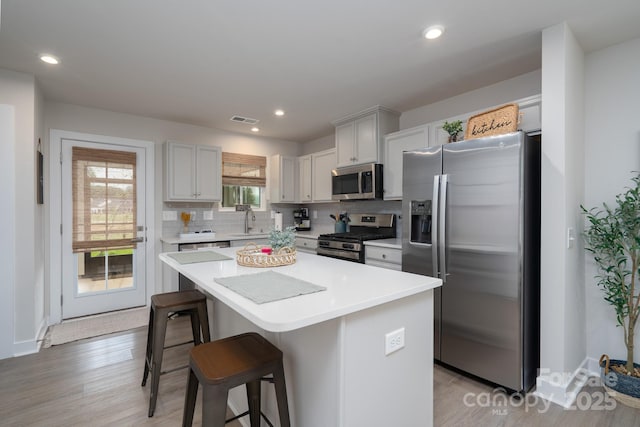 154 Stella Ln Unit A, Troutman, NC 28166 - kitchen with stainless steel appliances, a breakfast bar, a kitchen island, tasteful backsplash, and light countertops